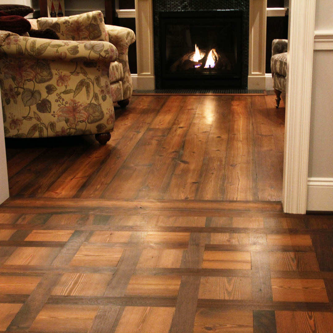 A custom design of mixed wood flooring provides a charming, historical feel to a hallway adjacent to a den.